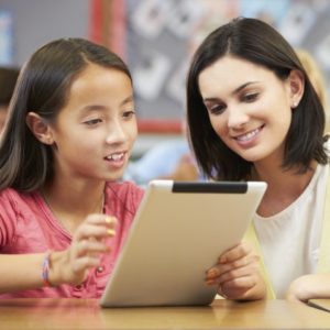 girl reading on a tablet with a woman